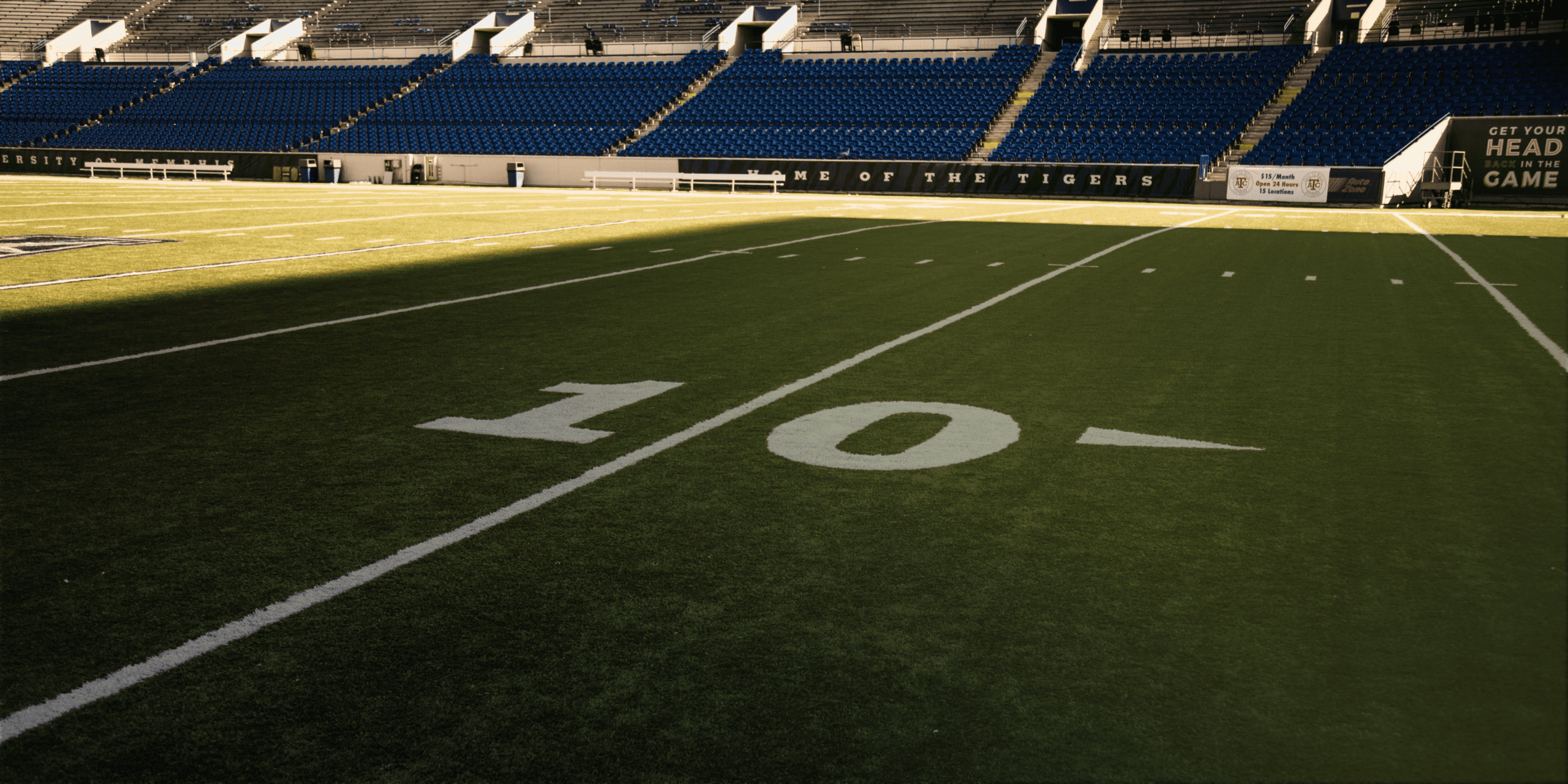 Football field darkened by a shadow, symbolizing the risk posed by this former pro-athlete to a leading bank.