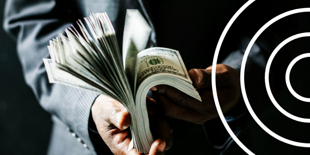 Person flipping through a stack of United States dollar bills, highlighting the ongoing struggles against corruption in Latin America.