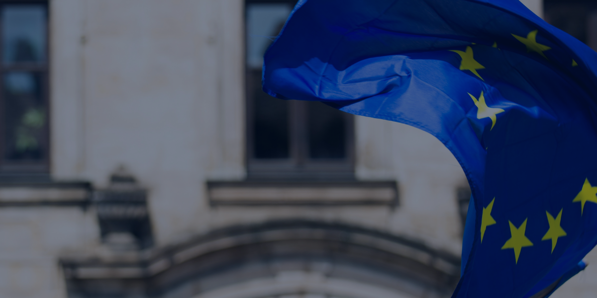 European Union flag waving in front of a building, highlighting the EU's decision to extend sanctions against Iran.