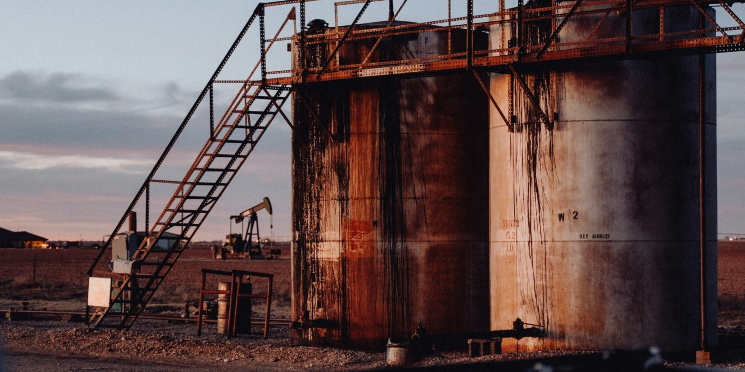 Two large oil barrels in a dessert, symbolizing our clients' potential partnership.