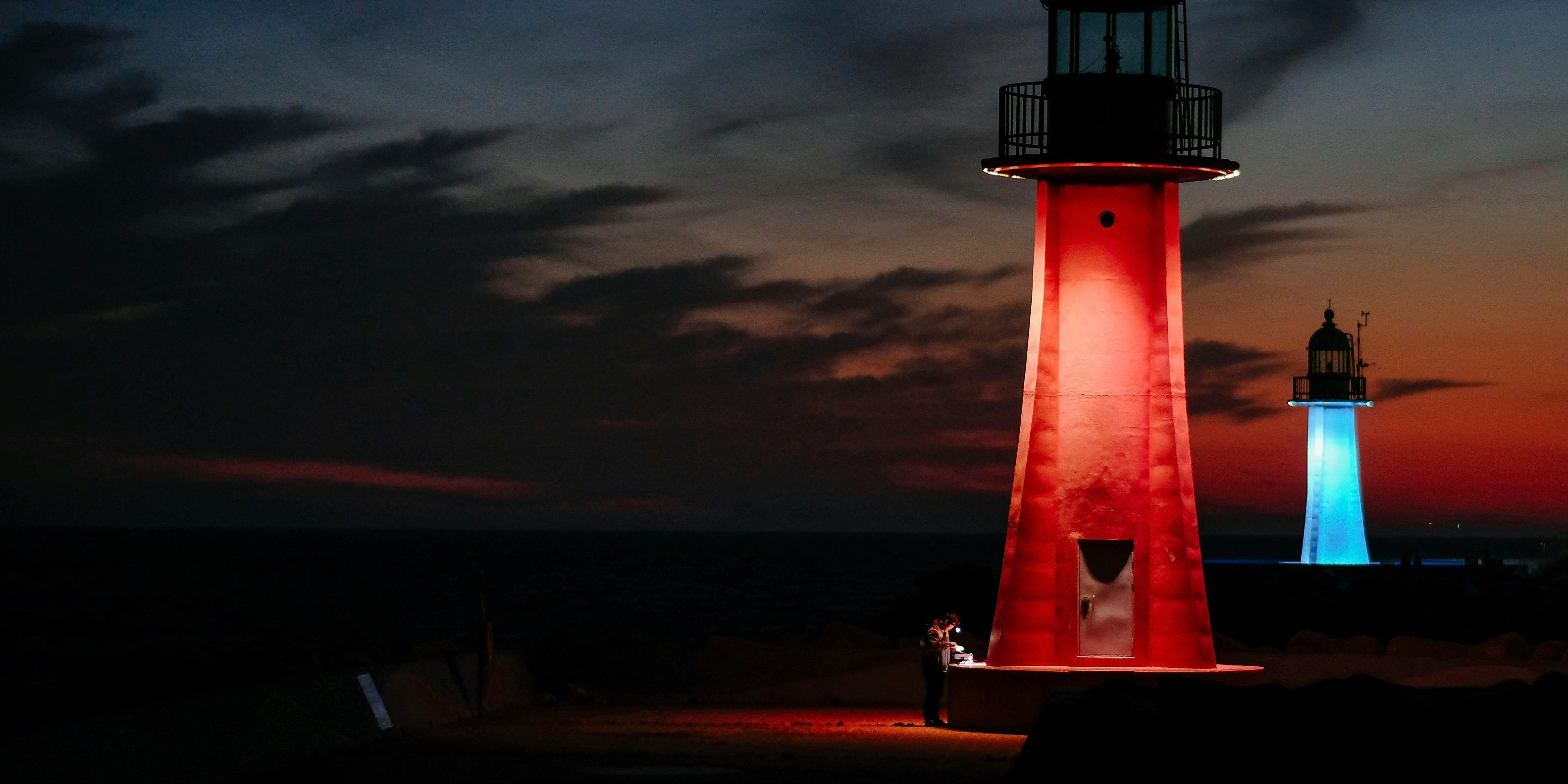 Person alone, tinkering near red lighthouse, signifying insider threat risk and ID verification tools.